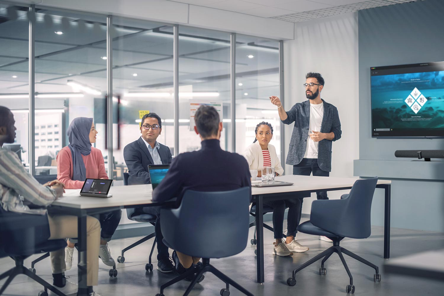 Man leading a business meeting with a presentation on a screen