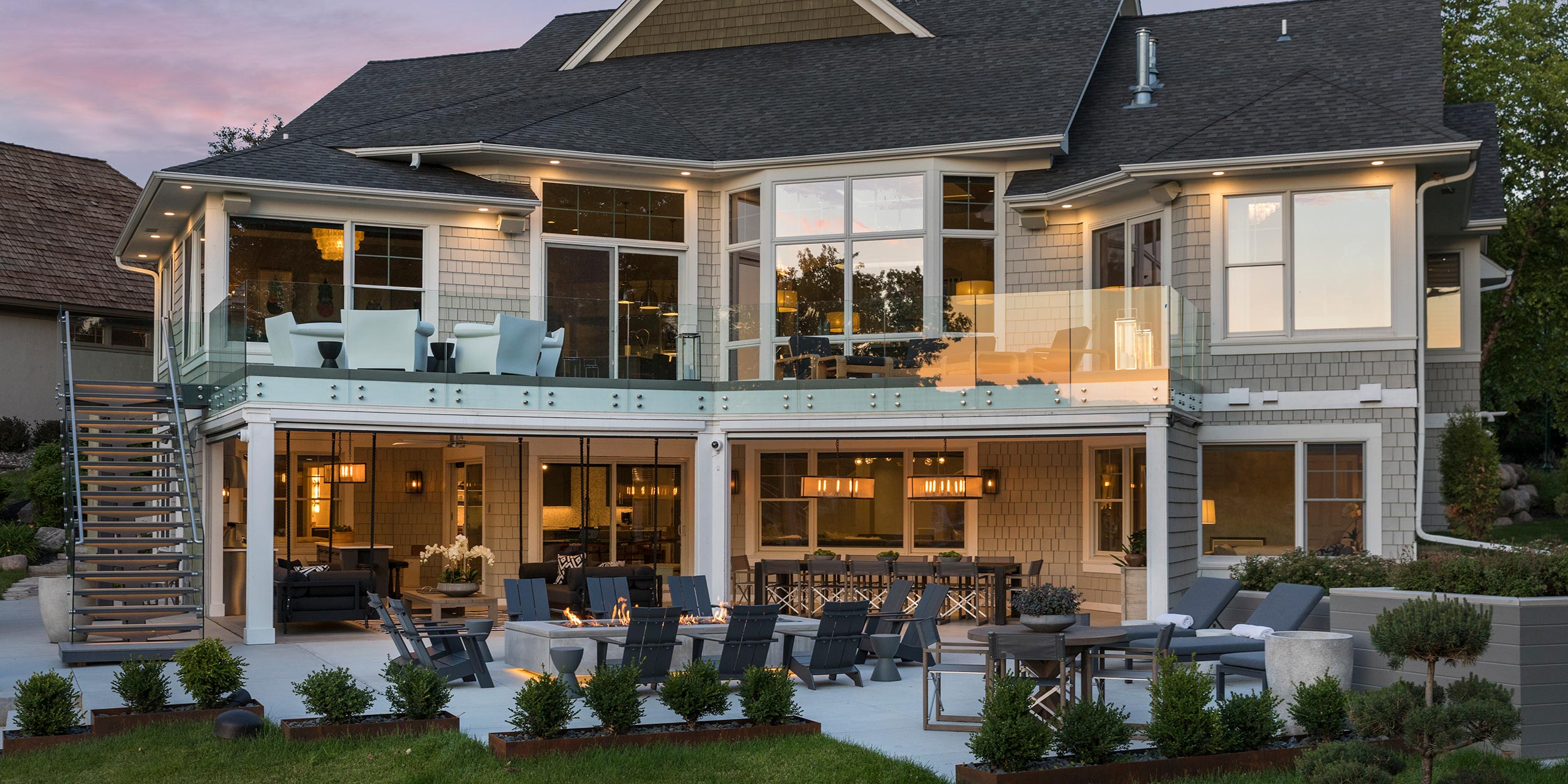 Elegant outdoor living space with a two-story patio and ambient lighting