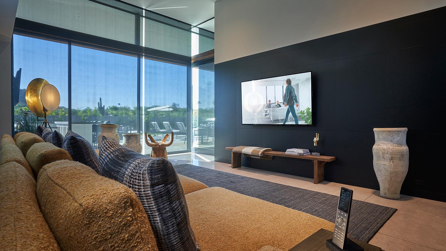 Modern living room with a large TV and floor-to-ceiling windows