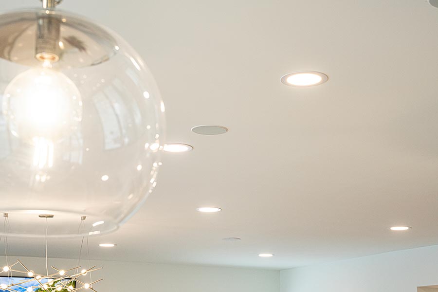 Close-up of ceiling with recessed lighting and integrated speakers