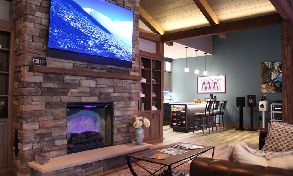Fireplace view showing connected kitchen area with pendant lights and bar stools