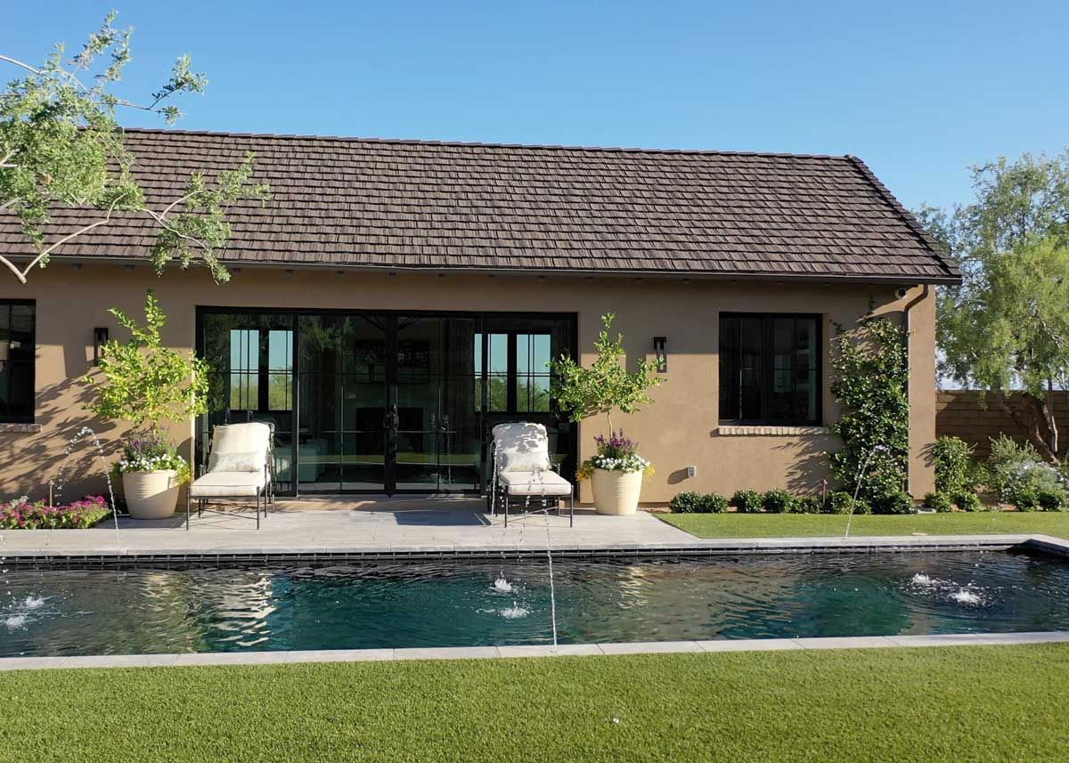 Poolside lounge area with a cascading waterfall and sleek landscaping