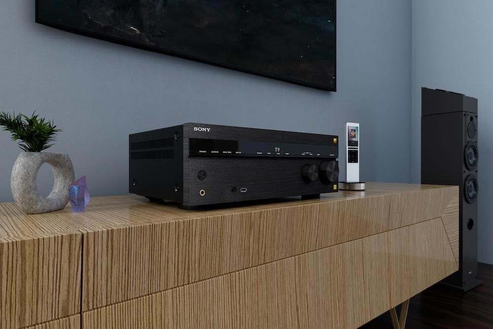 A Sony AV receiver placed on a wooden console table, paired with a sleek remote control and decorative items.