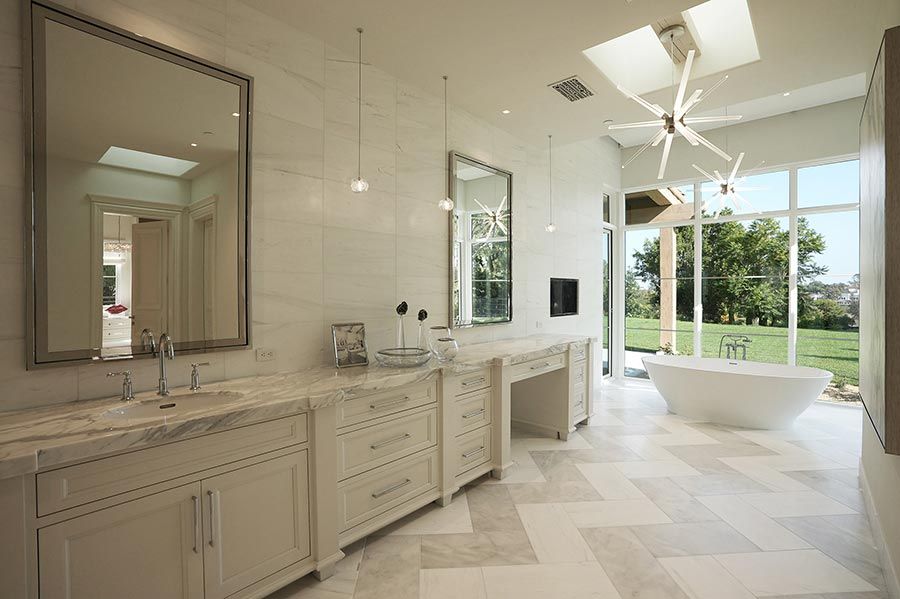 Elegant bathroom with marble countertops, large mirrors, and natural light