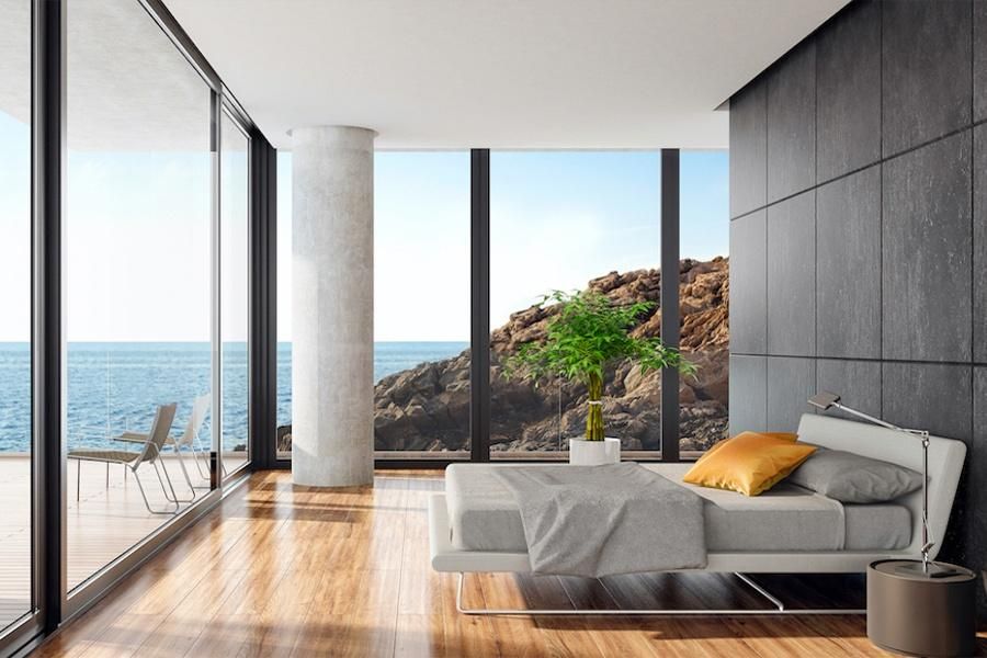 Modern bedroom with ocean view through large glass windows