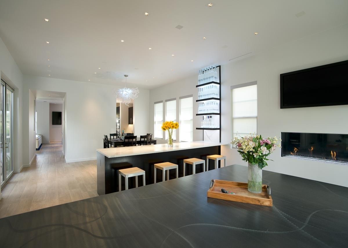 Bright kitchen and dining space with a long island and fireplace
