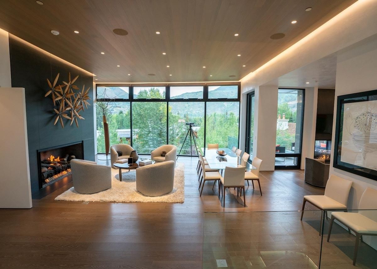 Modern living and dining space with large windows and scenic views