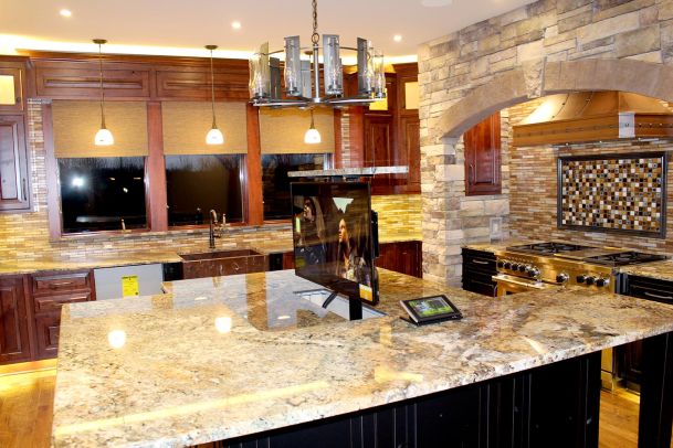Upscale kitchen with granite counters and hidden pop-up TV in center island