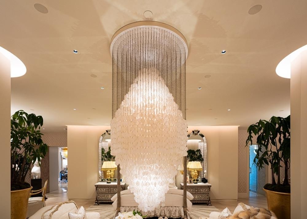 Luxurious bedroom with an elegant cascading chandelier and warm lighting