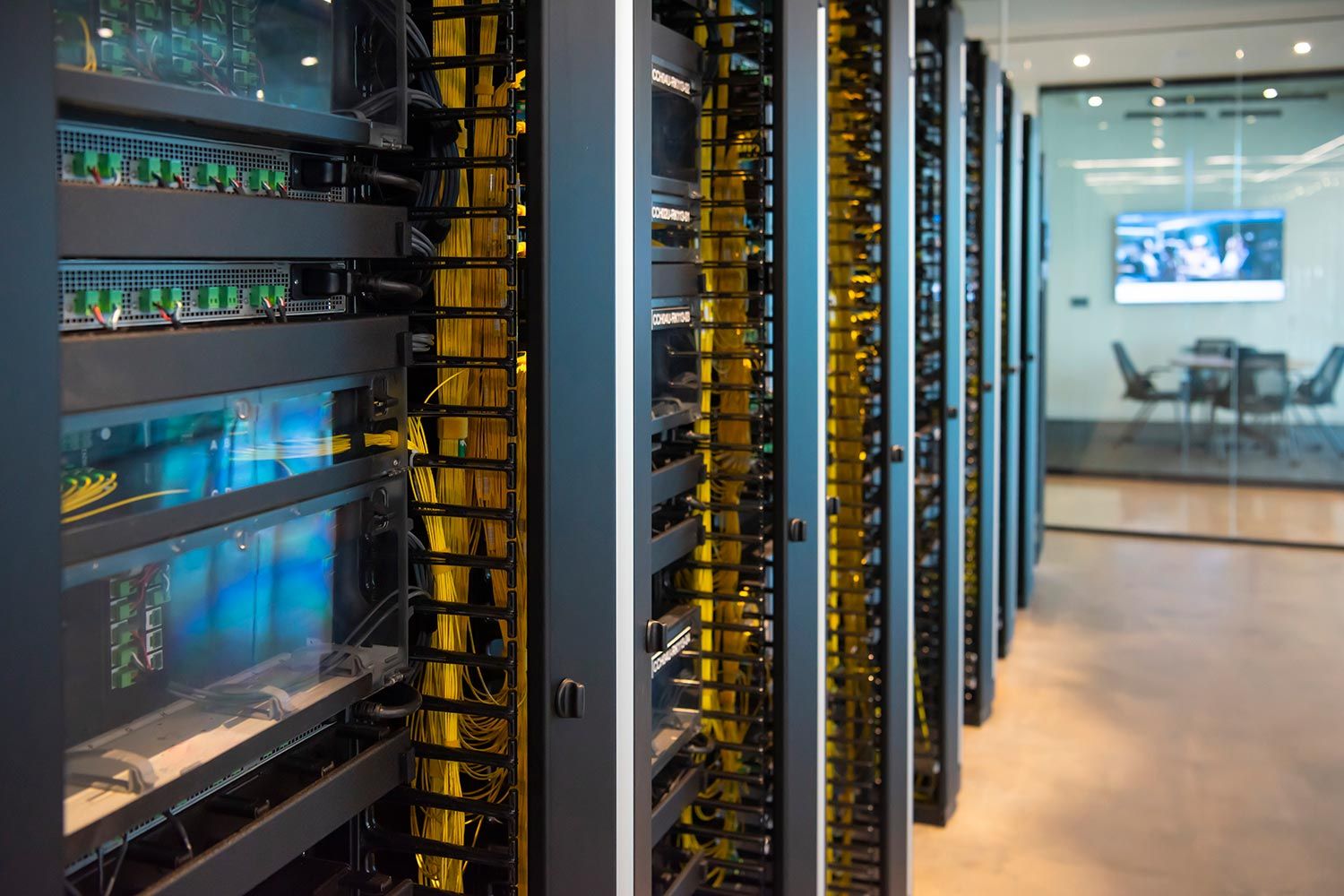 Server racks with neatly organized yellow cables in a modern office