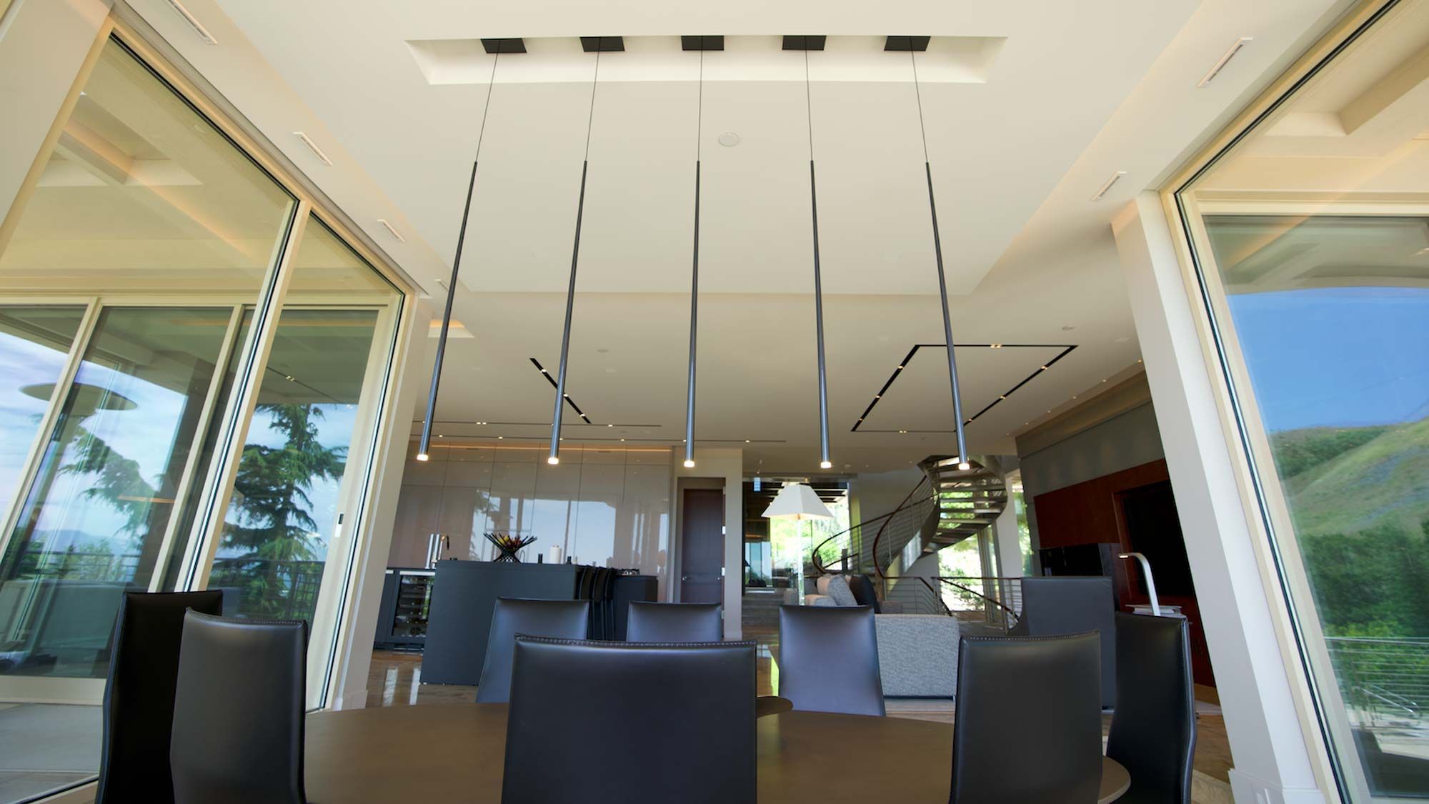 Contemporary dining area with sleek pendant lights and floor-to-ceiling windows