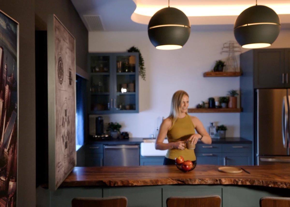 Modern kitchen with dark cabinets, wooden countertops, and pendant lighting