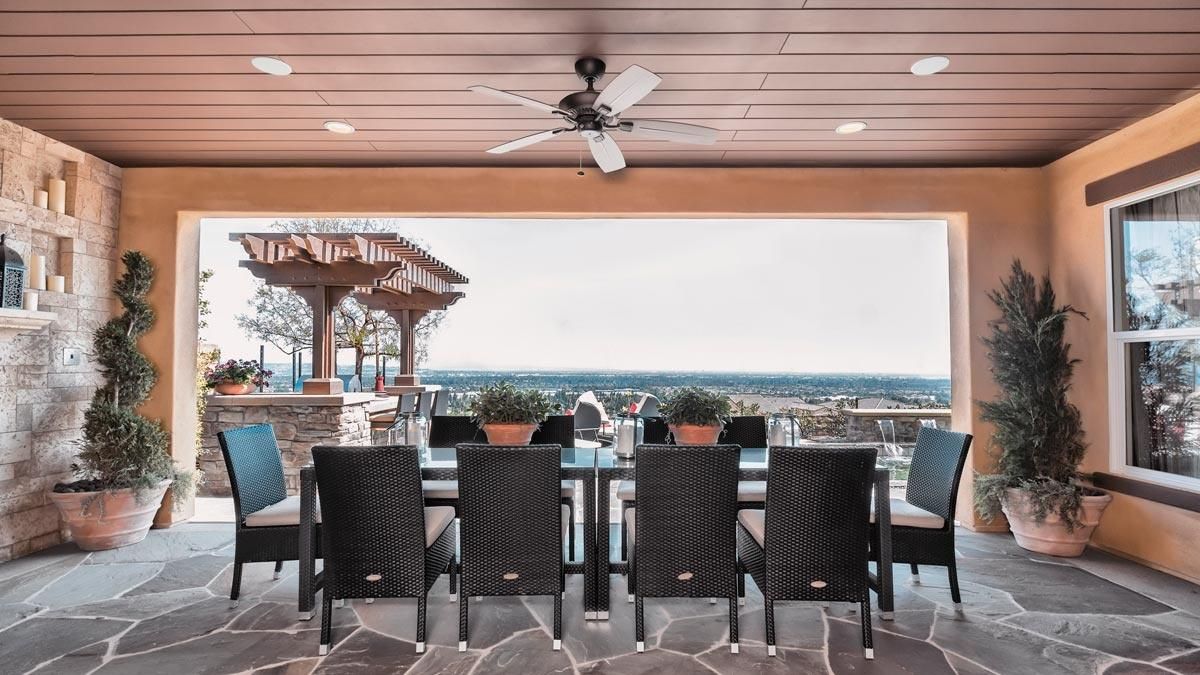 Covered patio dining area with a ceiling fan and scenic view