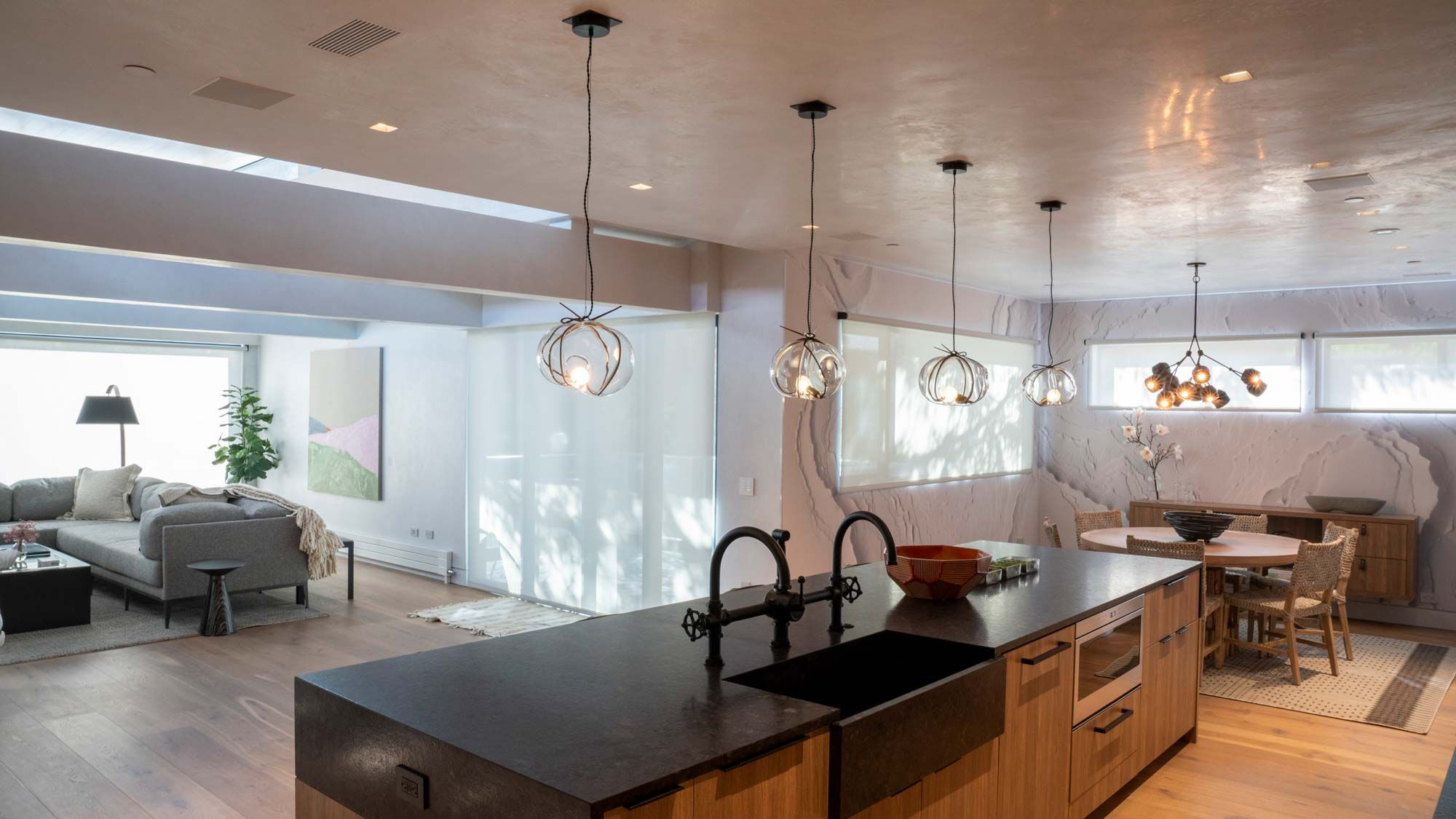 Open-concept kitchen and living space with stylish pendant lighting and natural textures