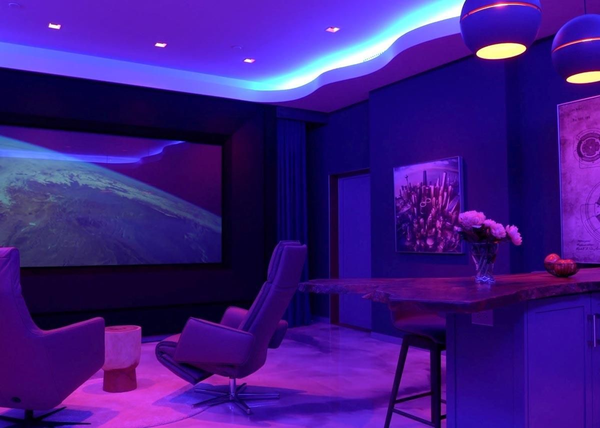 Home theater with ambient purple lighting and a large projector screen