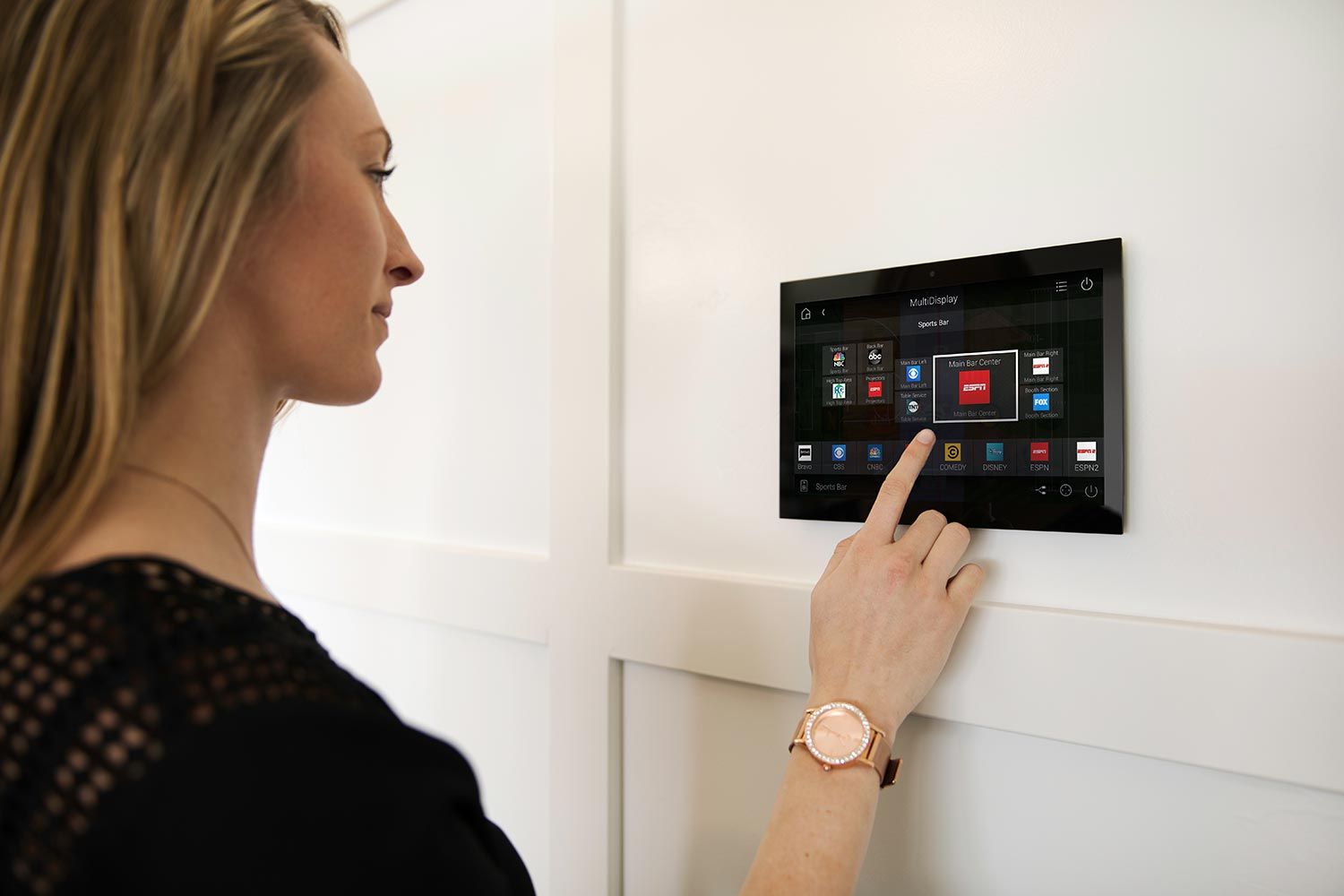 Woman using a wall-mounted smart home control panel