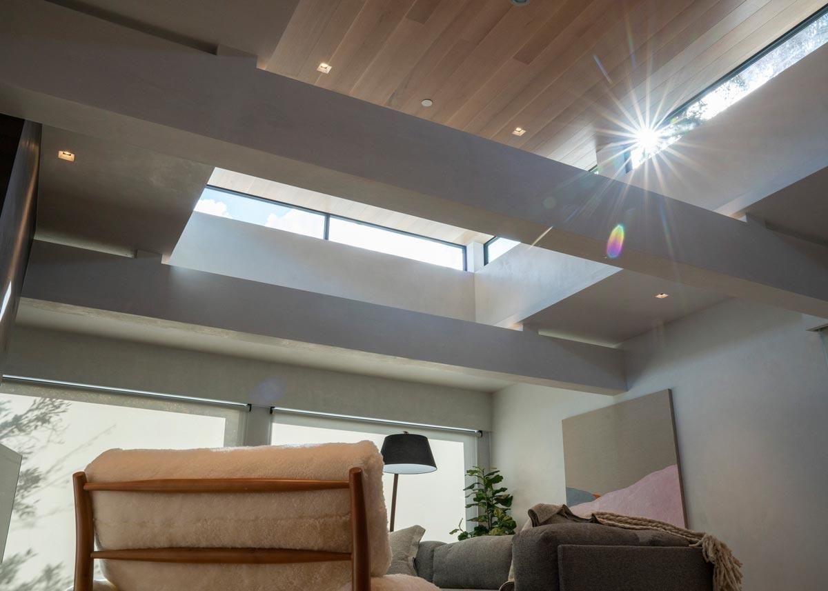 Cozy living space with layered ceiling beams and natural sunlight
