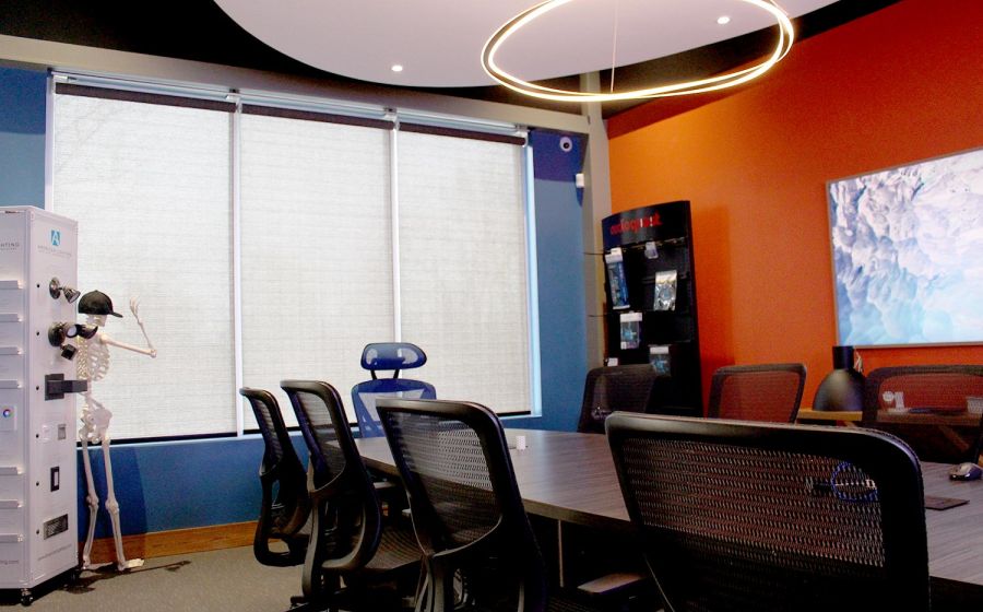 Conference room with orange accent wall, round light fixture, and skeleton model