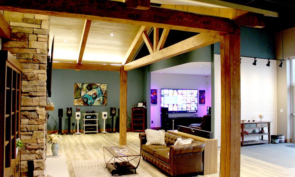 Modern showroom interior with wooden beams, a stone fireplace, and leather seating