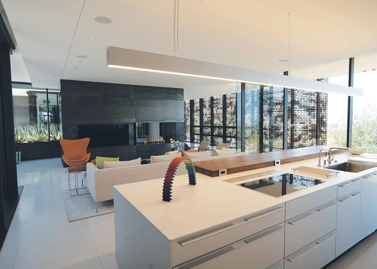 Modern kitchen with dark cabinets, wooden countertops, and pendant lighting