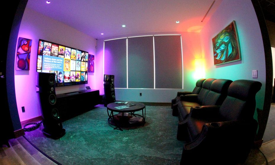 Home theater room with purple lighting, movie posters, and leather recliners